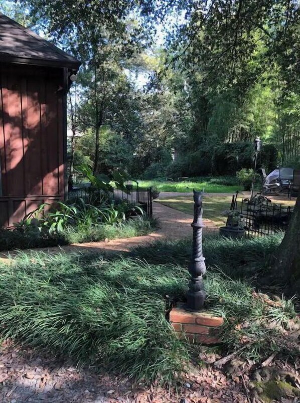 A rustic wooden building with a pathway leading through a garden.