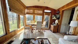Un salon spacieux avec une grande fenêtre, un coin repas et un espace salon confortable.