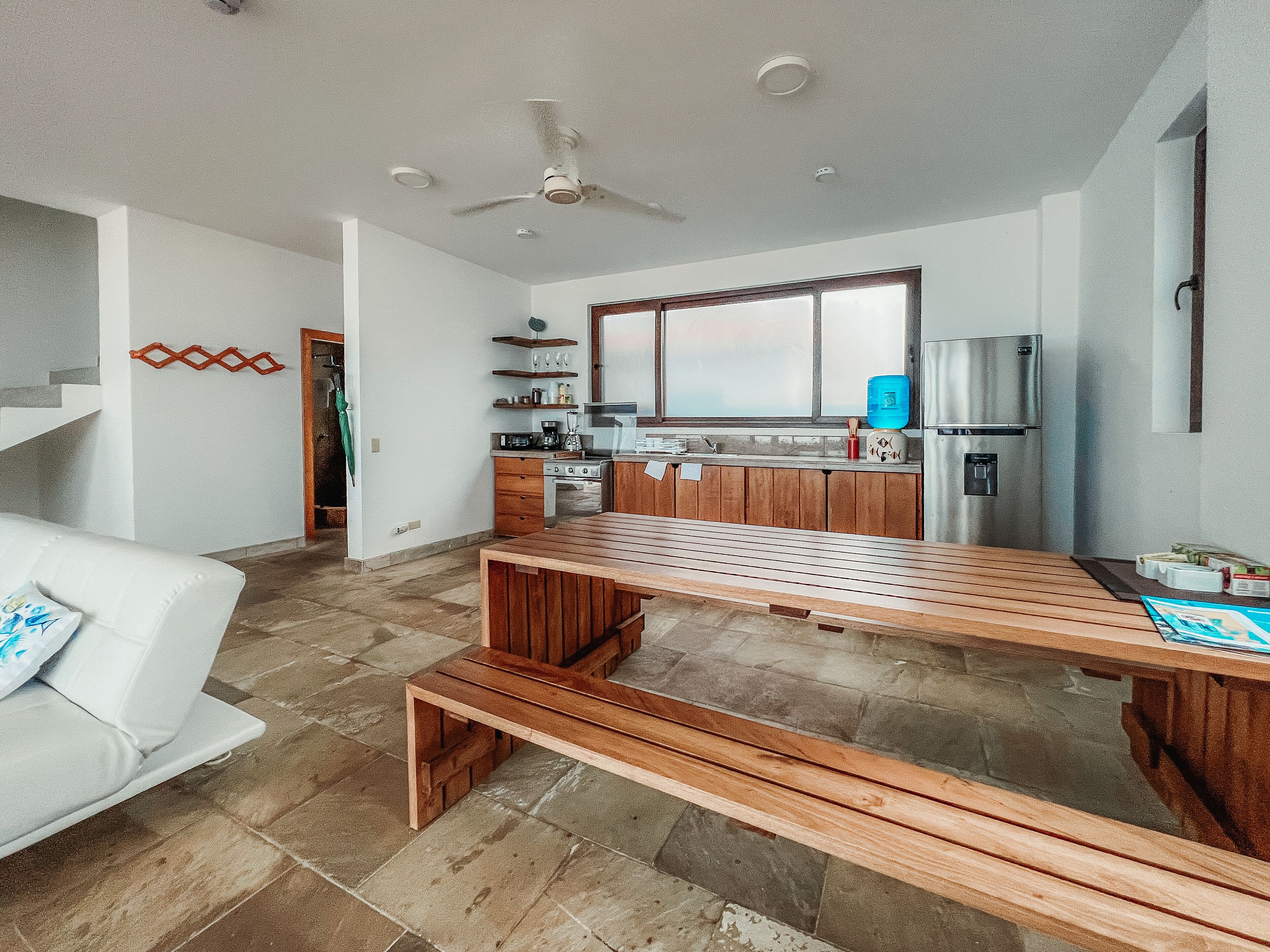 A modern kitchen with wooden cabinets, a built-in oven, and a stainless steel refrigerator.