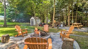 Un patio al aire libre con sillas de madera y una chimenea.