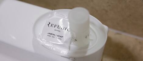 A bottle of Refugio Hotel Jabon / Soap on a white surface.