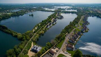 Vista aérea de una zona residencial junto al lago, con casas a lo largo de la orilla, un puerto deportivo y barcos en el agua.