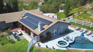 A house with solar panels, a swimming pool, and a fenced patio area. - House with pool/spa/minutes to wineries (Temecula)
