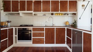 Una cocina con armarios de madera, estufa, horno, fregadero y lavavajillas.