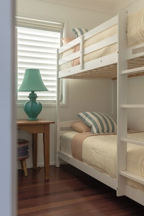 Une chambre avec un lit superposé, un bureau et une lampe.