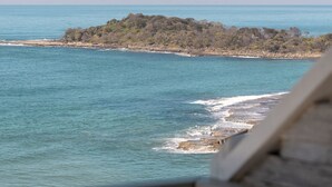 A coastal view with a rocky island and calm sea.