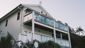 A two-story house with a balcony and a staircase leading up to it.