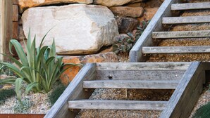A staircase with wooden steps leading up to a stone wall.