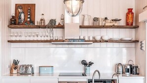 A modern kitchen with white cabinetry, a central island, and various kitchen appliances.