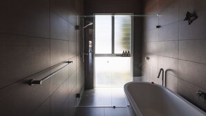 A modern bathroom with a glass shower enclosure, a freestanding bathtub, and a visible toilet. - BAY PROPERTIES | The Chill (Yamba)