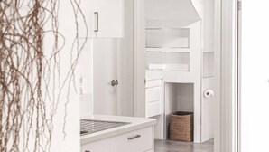 Une salle de bain moderne avec un lavabo blanc, un miroir et un porte-serviettes.