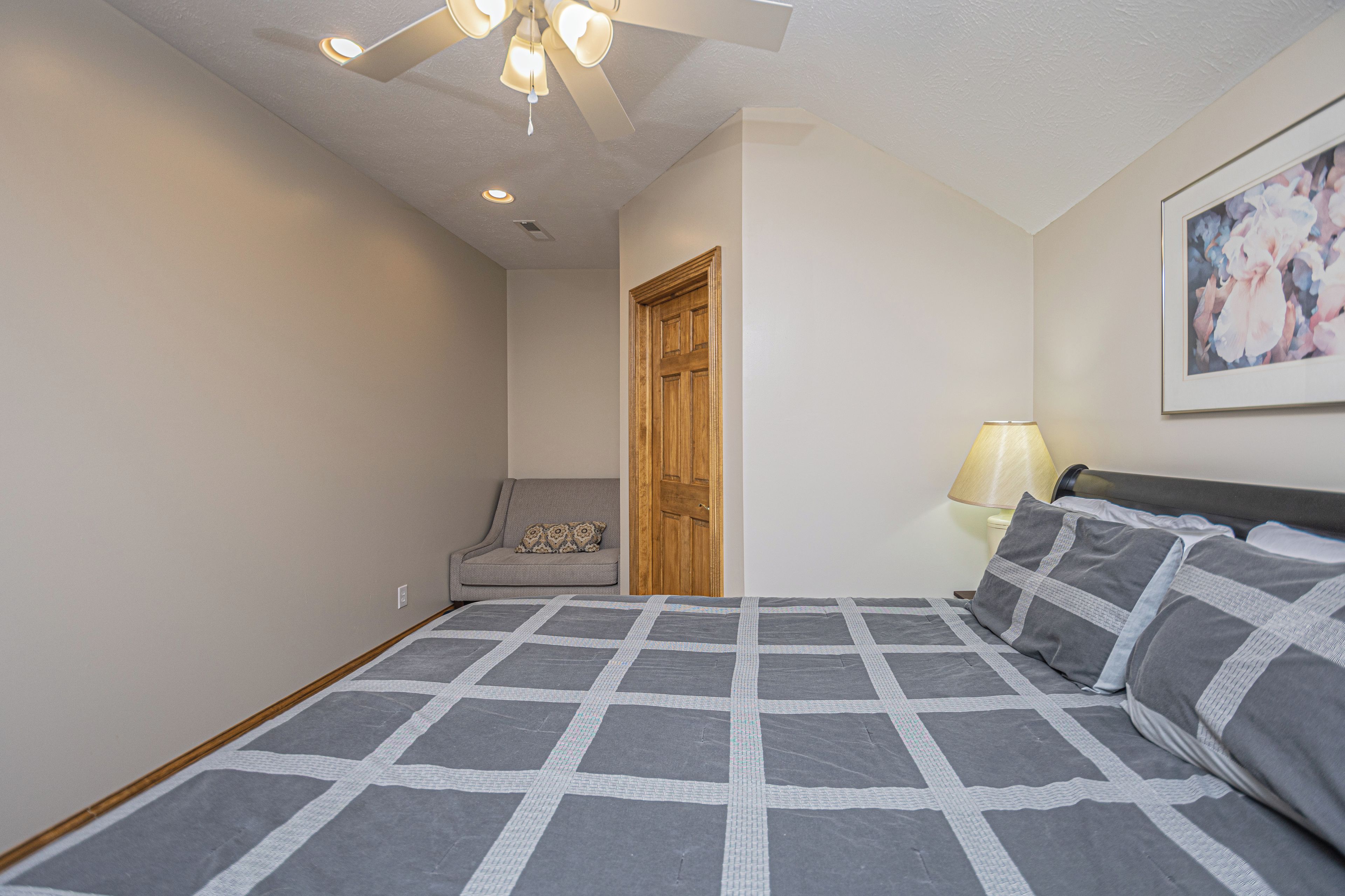 Ein Schlafzimmer mit Bett, Stuhl, Tür und Lampe.