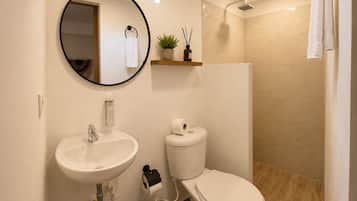 A modern bathroom with a sink, toilet, and shower.