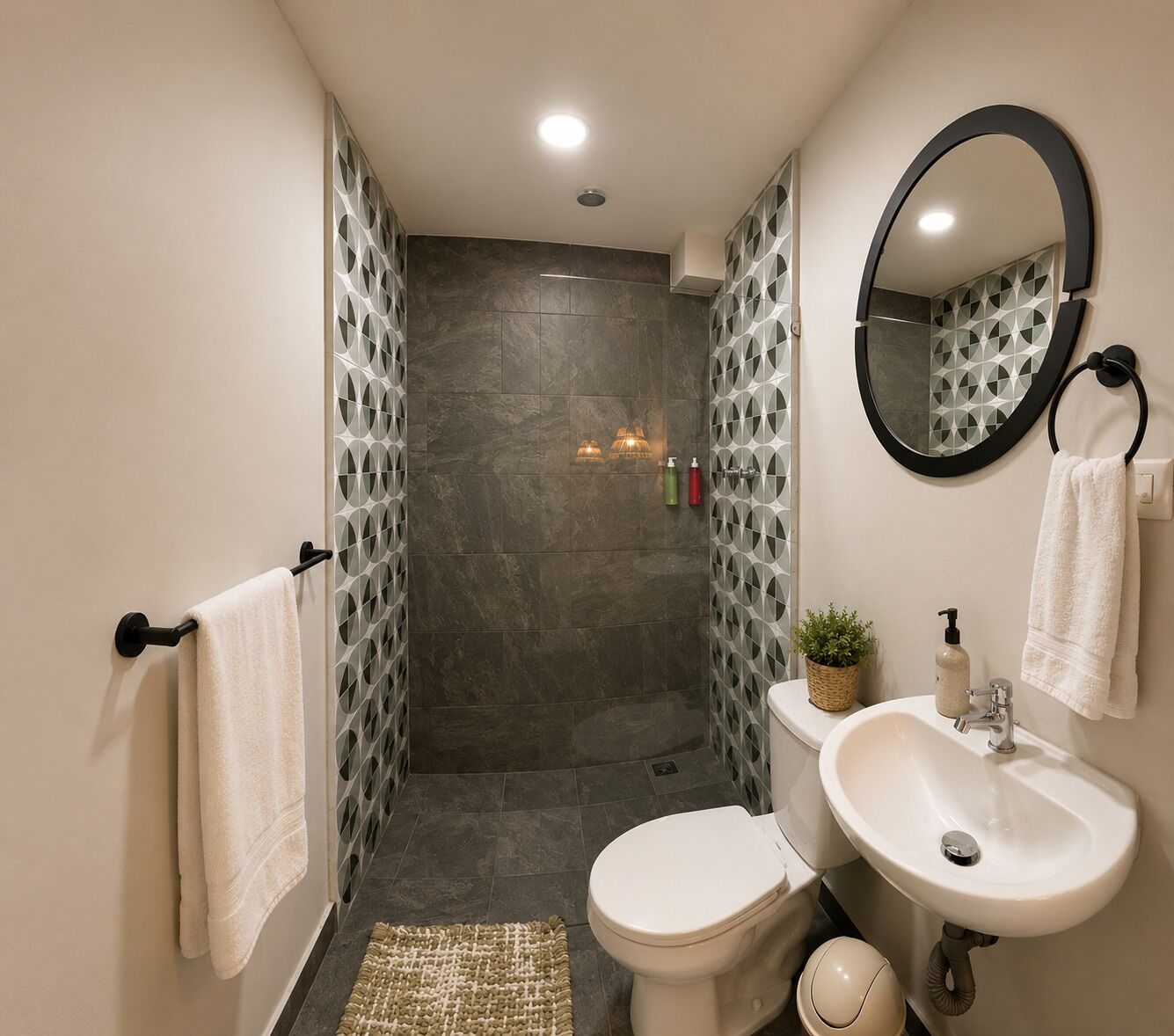 Une salle de bain moderne équipée d’une douche, de toilettes, d’un lavabo et d’un miroir.