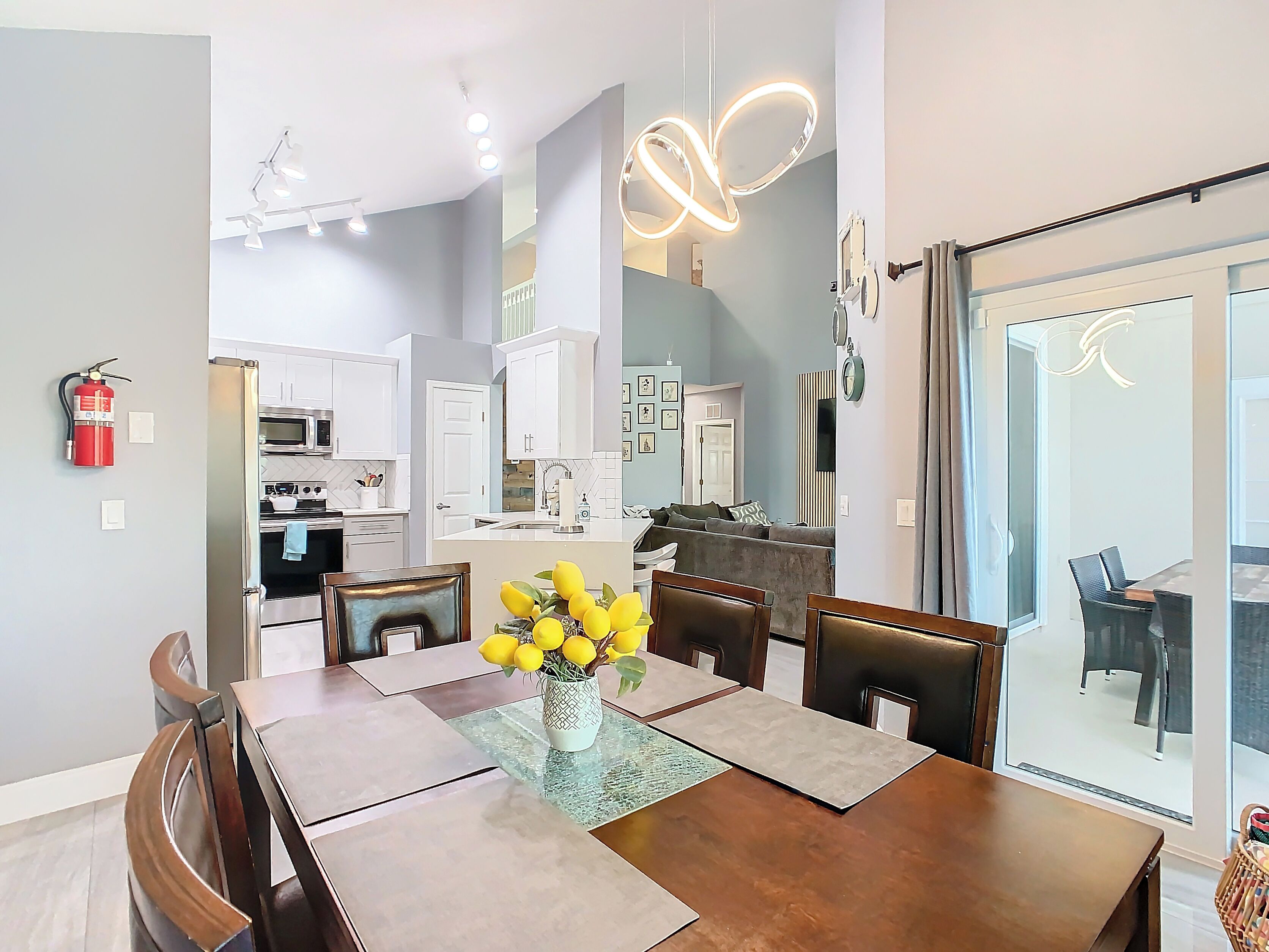 A modern kitchen with white cabinets and a dining area with a wooden table and chairs.
