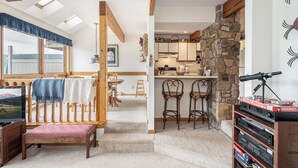 A cozy room with a wooden bed, a desk, and a stone wall. - Ski Harbor 14 by Taylor Made Deep Creek (McHenry)
