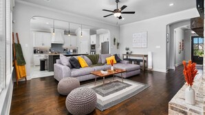 Un salon moderne avec un canapé gris, une table basse en bois et des poufs ronds.