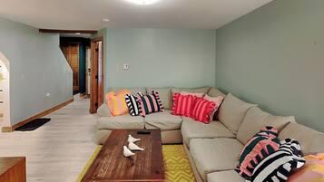 Un salon avec un canapé, une table basse et un tapis à motifs.
