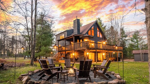 A cabin with a deck, outdoor seating, and a fire pit. - Woodhaven by Taylor Made Deep Creek (Swanton)