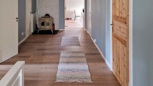 Un couloir doté d’un plancher en bois, d’un tapis à motifs et d’une vieille armoire.