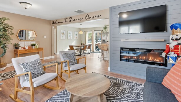 A modern living room with a fireplace, a television, and comfortable seating.