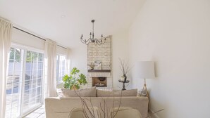 Una sala de estar moderna con un sofá, una mesa de comedor y una chimenea.