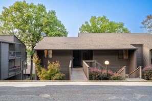 A two-story building with a front porch, a staircase, and a satellite dish.
