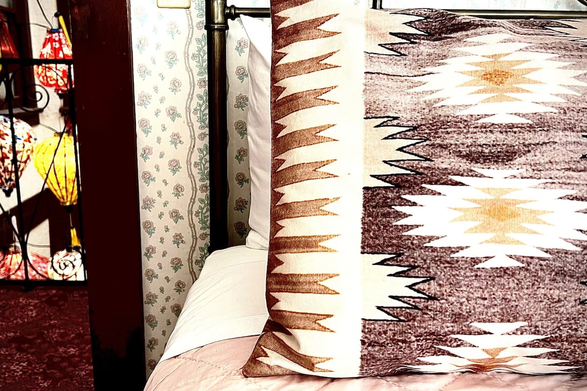 A room with a patterned rug, a curtain with floral print, and hanging lamps with floral designs.