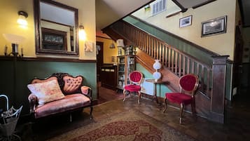 Classic design with a wooden staircase, polished floor, and comfortable seating areas.