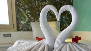 Una cama con una toalla doblada en forma de dos cisnes.