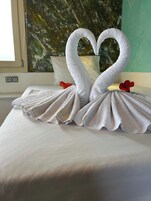 Una cama con una toalla doblada en forma de dos cisnes.