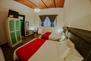 A hotel room with two beds, a desk, a chair, a wardrobe, and a window with curtains. - GRAN ALCAZAR HOTEL BOUTIQUE (San Luis Potosi)