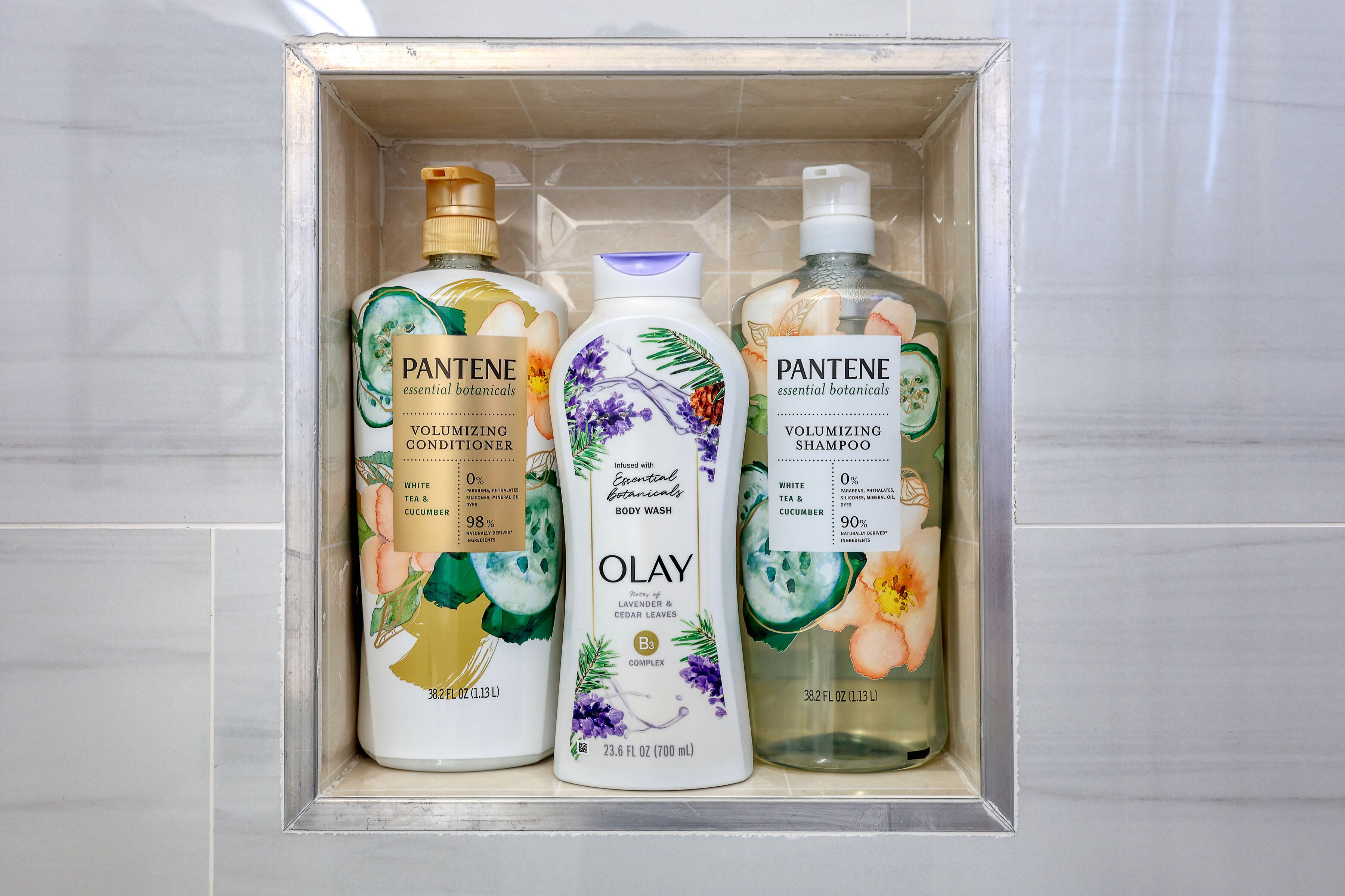 Een badkamerplank met drie flesjes Pantene en één fles Olay body wash.