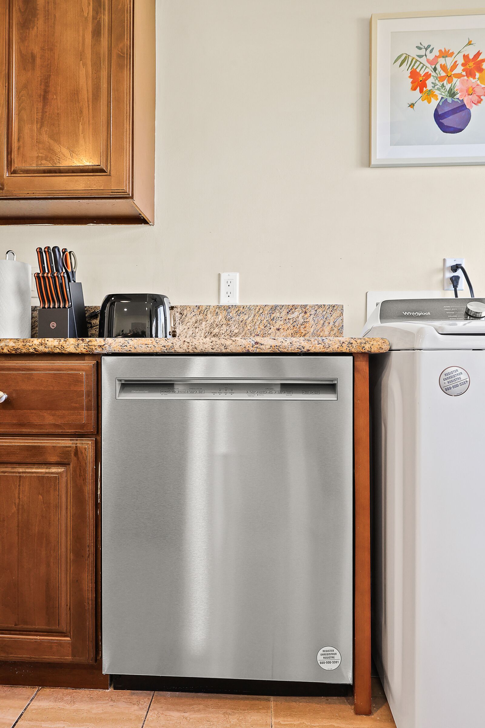 A kitchen with a dishwasher, a toaster, and a refrigerator.