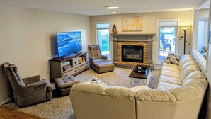 Una sala de estar con chimenea, televisor y sofá.