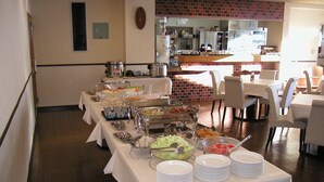 Un buffet avec différents stands de nourriture et un mur de briques en arrière-plan.