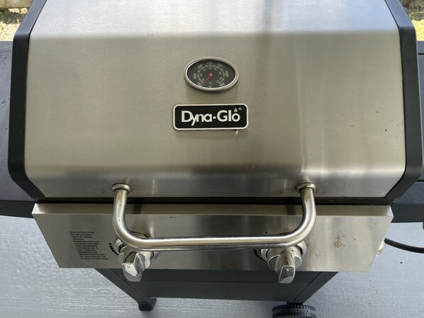 A stainless steel grill with a digital thermometer and a handle for easy access.