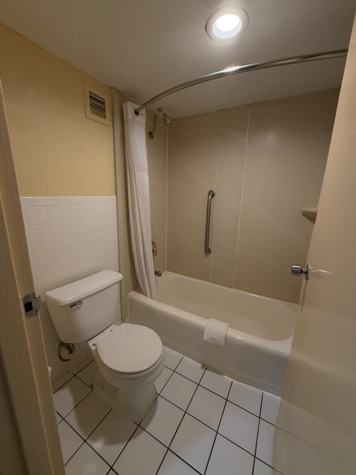 A bathroom with a toilet, bathtub, and shower.