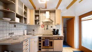 A compact kitchen with a built-in oven, a coffee maker, and a microwave.