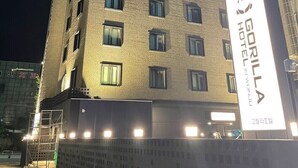 Un immeuble à plusieurs étages sur lequel on peut lire l’inscription « HÔTEL GORILLA À YONKONG ».