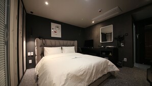 Une chambre à coucher moderne avec un grand lit, un bureau et un miroir.
