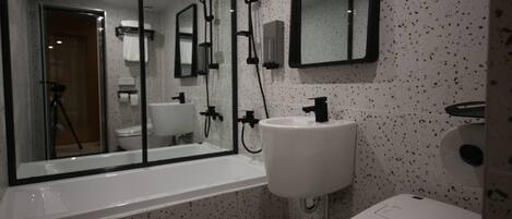Un baño con bañera, lavamanos e inodoro.