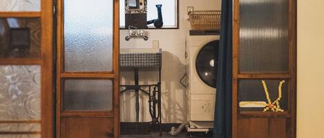 A tatami mat room with a traditional Japanese aesthetic, including a shoji screen door, a futon bed, and a low table with a tea set.