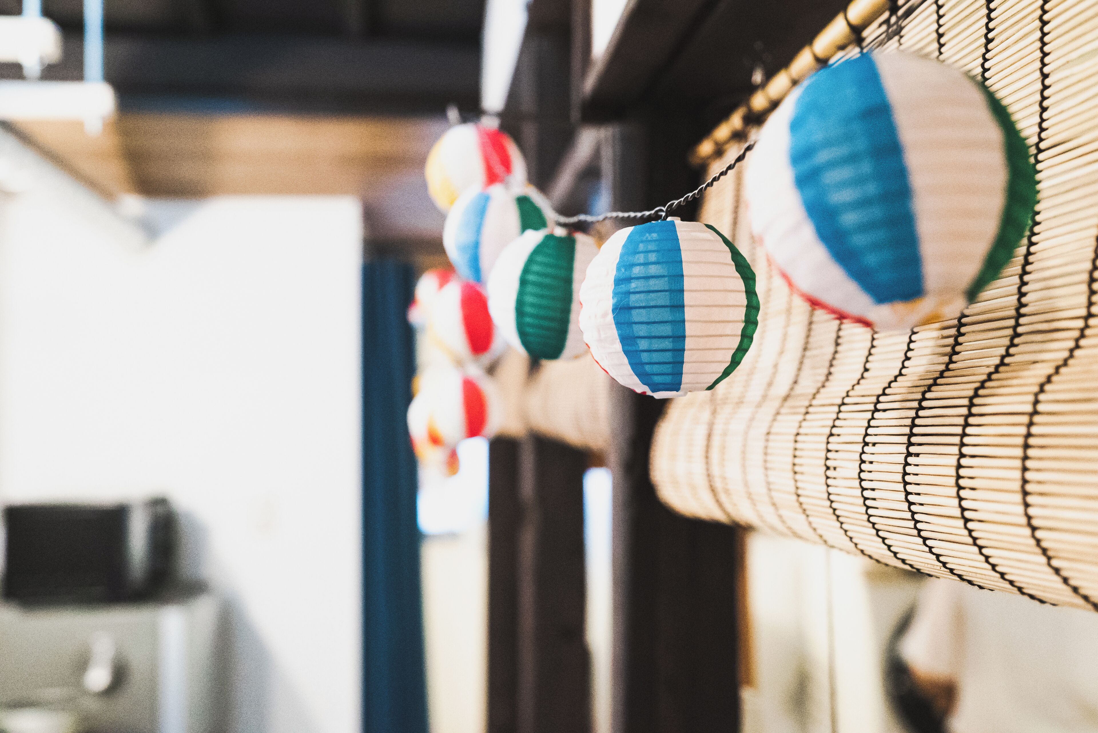 En rad traditionella japanska papperslyktor hänger från taket.