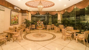 Un espacio interior bien iluminado con muebles de madera, un arreglo floral central y un suelo con diseño.