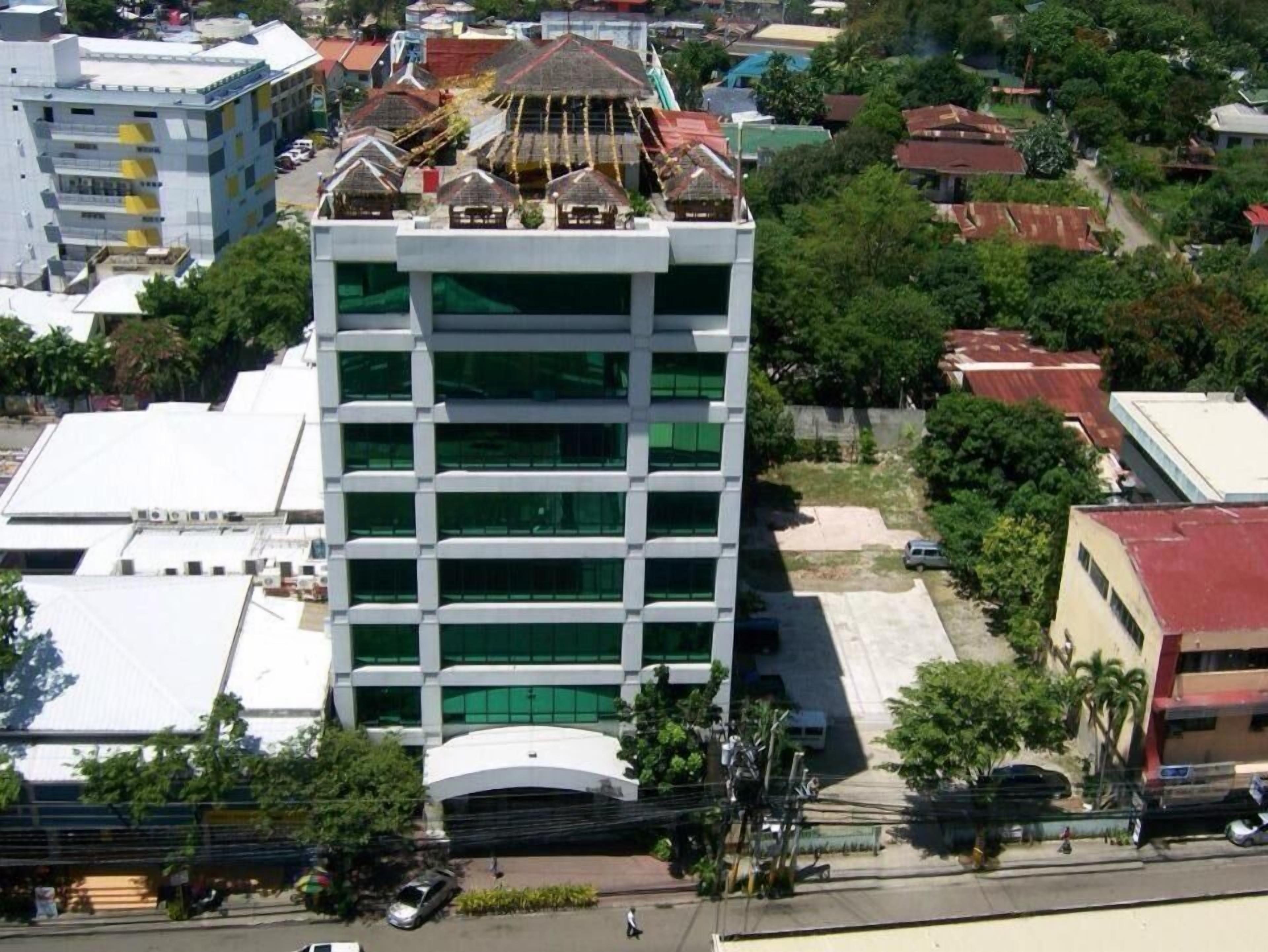 A multi-story building with a modern architectural design, featuring a central courtyard and a flat roof.