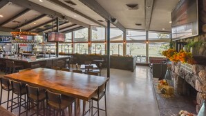 A spacious indoor area with a bar, seating, and a fireplace. - Flagstaff Bogey Inn! A-Frame cabin Golf Course Lot (Flagstaff)