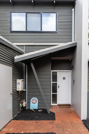 Stylish two-story residence with a modern design, featuring a large overhanging roof and entrance.