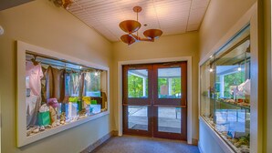 A hallway with a wooden door, a ceiling fan, and glass display cases on either side. - The Woods Resort and Spa Killington: 2 BR / 2 BA Renovated Condos w/ Great Amenities V7 (Killington)
