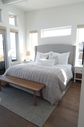 Un dormitorio con una cama grande, un banco y una ventana.